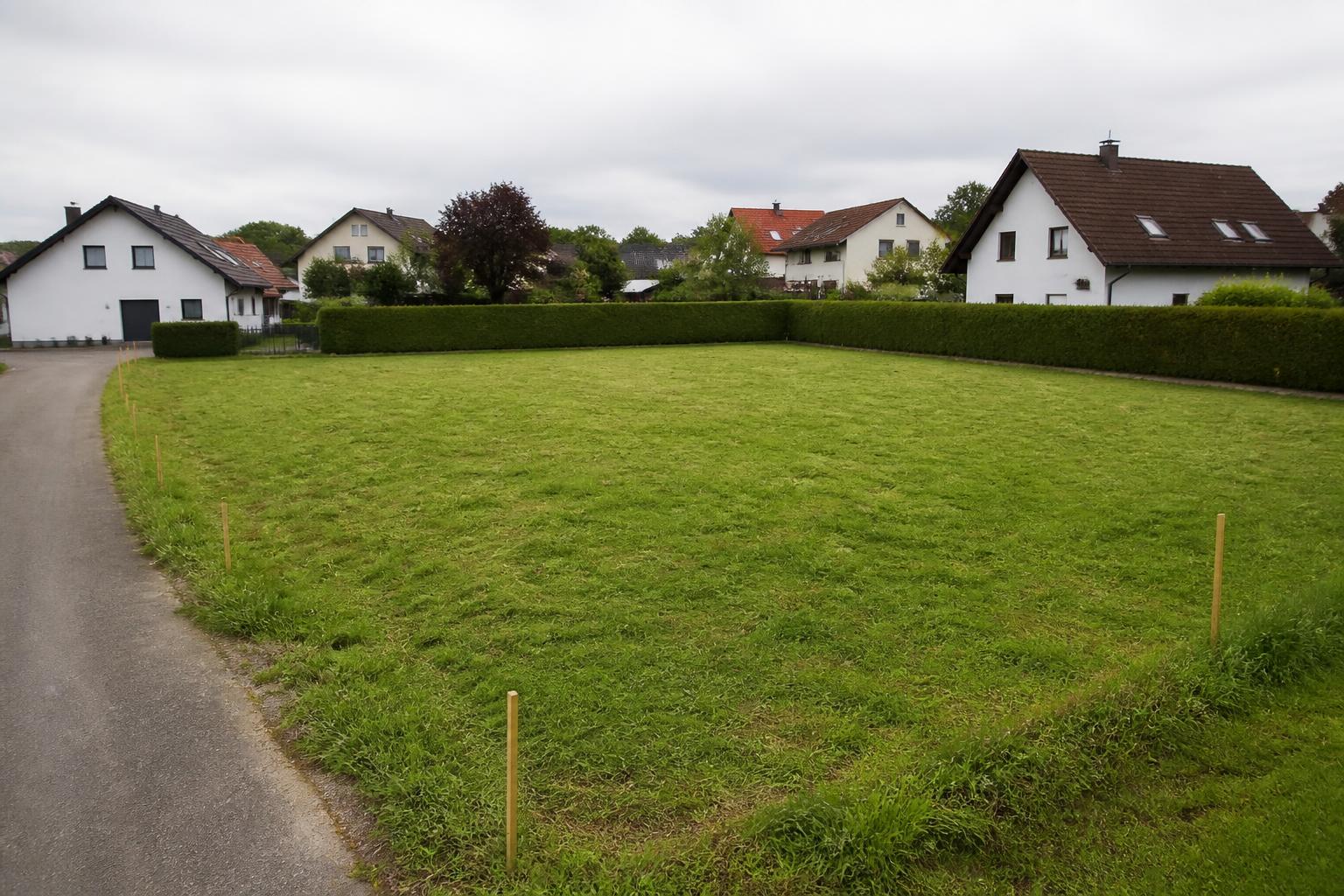 Unbebautes Grundstück am Ortsrand mit Vermessungspflöcken